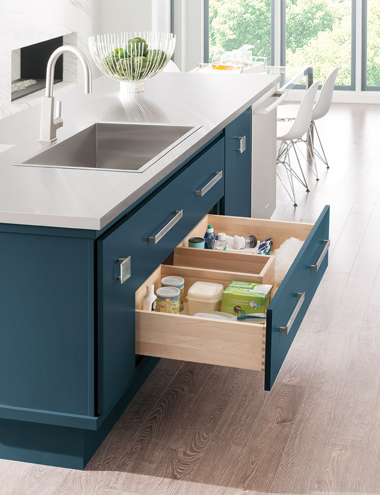 Deep blue kitchen island featuring premium cabinet brands with a drawer of supplies and food.