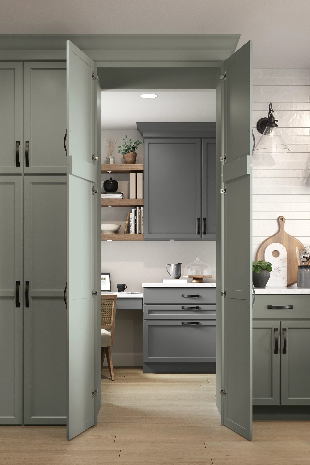 Open sage green pantry doors revealing a small kitchen office for a cabinet design consultation.