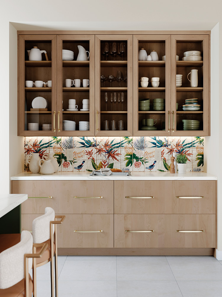 Wood kitchen cabinets with glass upper doors, patterned tile backsplash, and gold hardware.