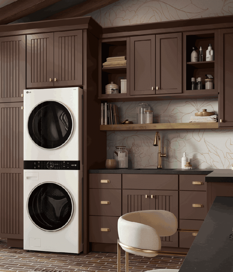 White stacked LG washer and dryer enclosed in brown kitchen cabinets.
